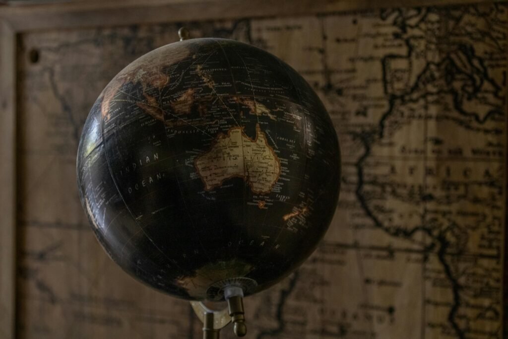 A vintage globe showcases Australia with a sepia world map in the background, offering a classic exploration theme.