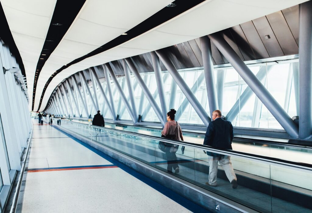pexels-photo-34134 Travelers walking through a bright modern airport corridor with glass walls.