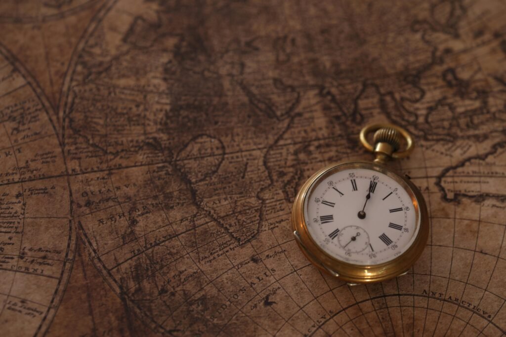 A classic pocket watch rests on an old world map, evoking a sense of history and time travel.