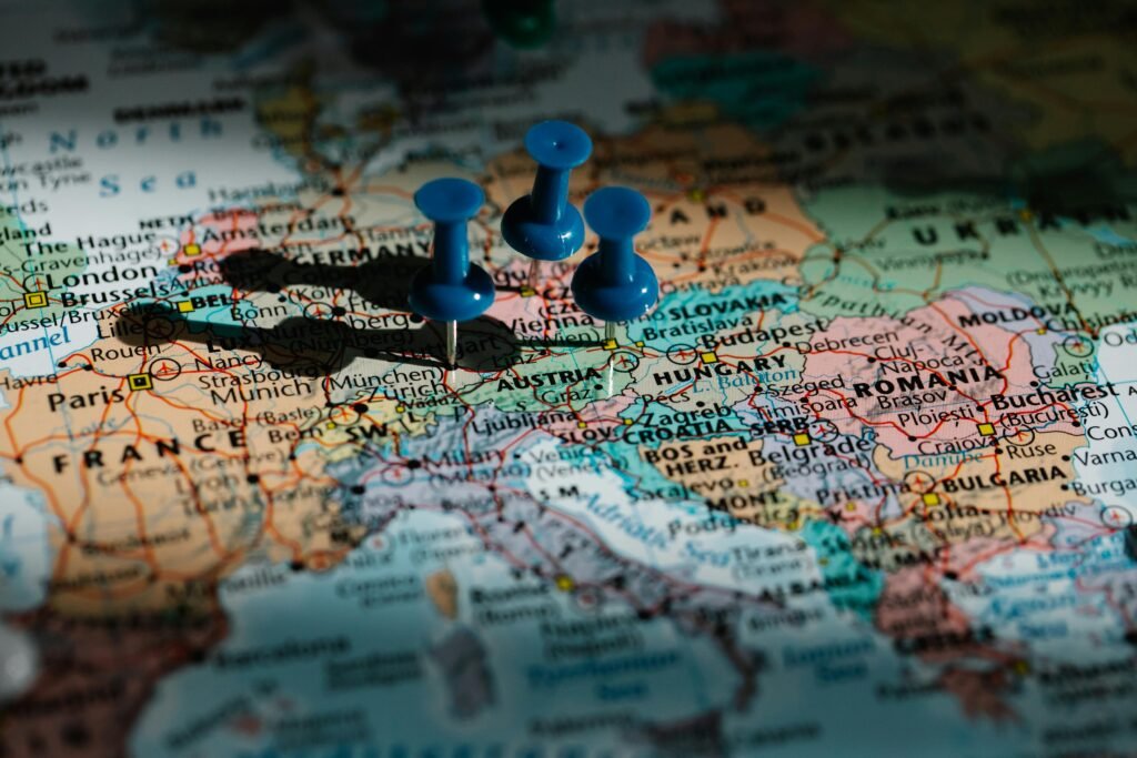pexels-photo-8828587-8828587 Detailed close-up of a European map with blue pushpins marking important locations.